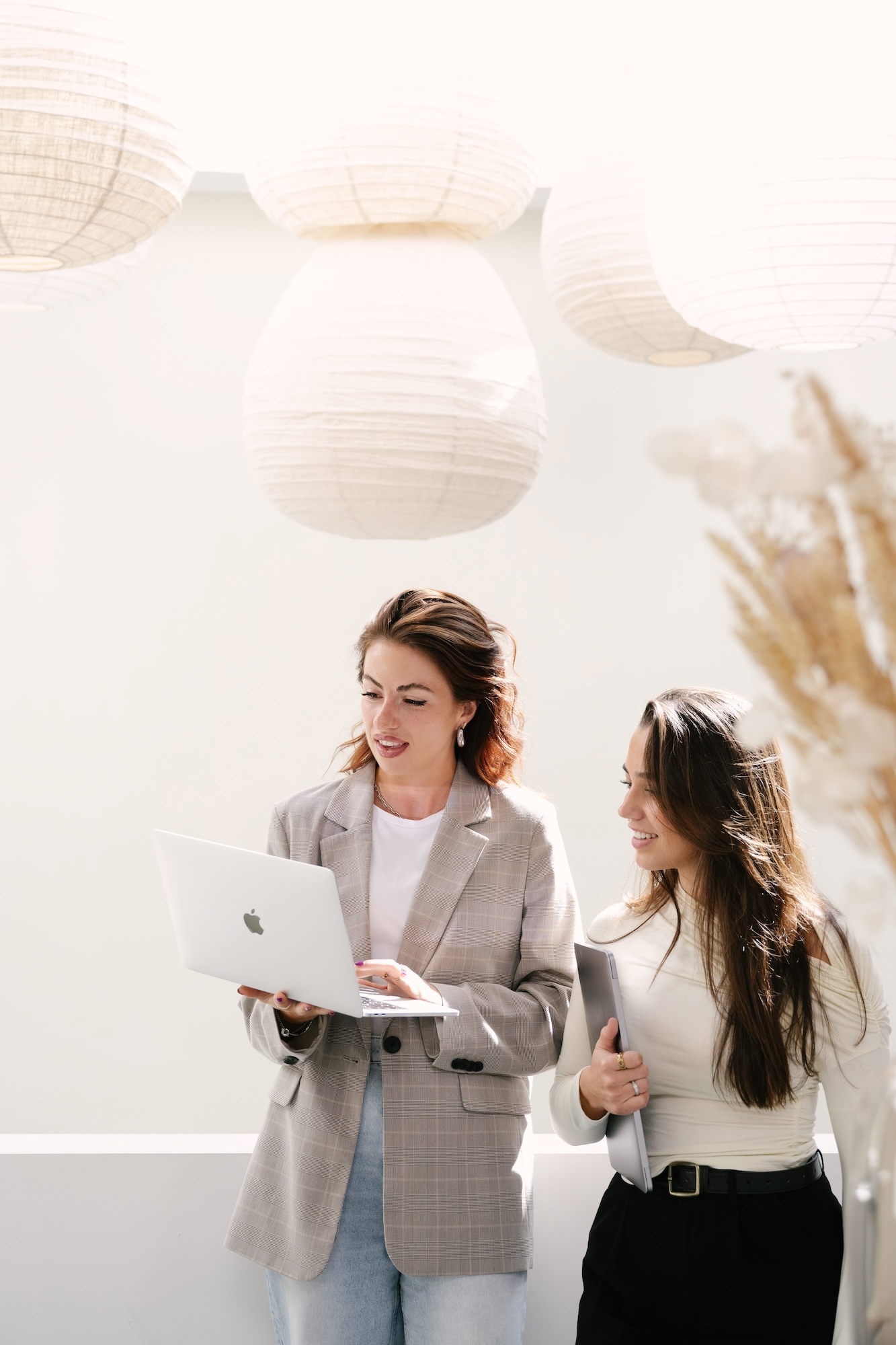 Two young professionals collaborating outdoors with a laptop at YOUNG workspace